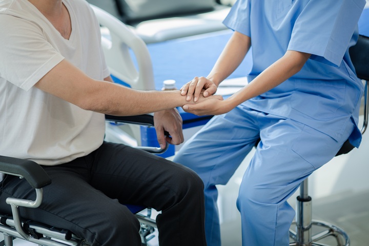 Male patient sitting in wheelchair undergoing a medical examination with specialist physician, treating injuries Getting medical treatment from specialist doctor can get the right and proper treatment